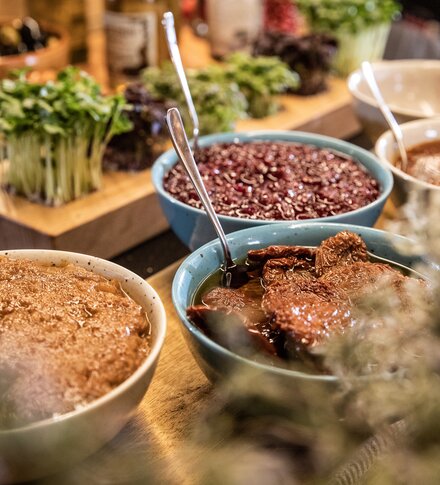 Frühstücksbuffet mit verschiedenen Schüsseln gefüllt mit Aufstrichen, Bohnen und Sprossen