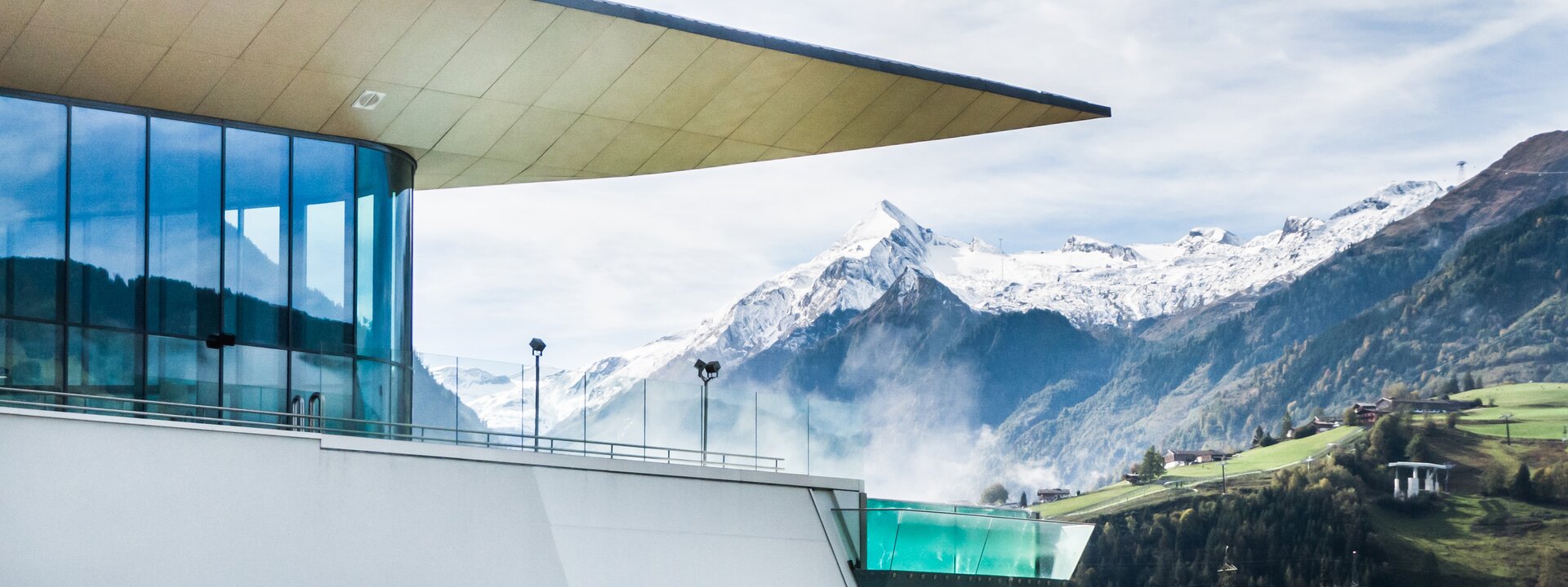 Building with rooftop pool in front of snow-capped mountains