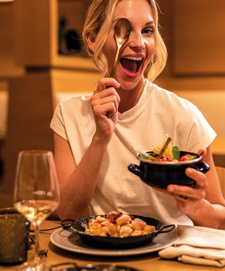 Frau hält Schüssel mit Essen in der Hand und lacht