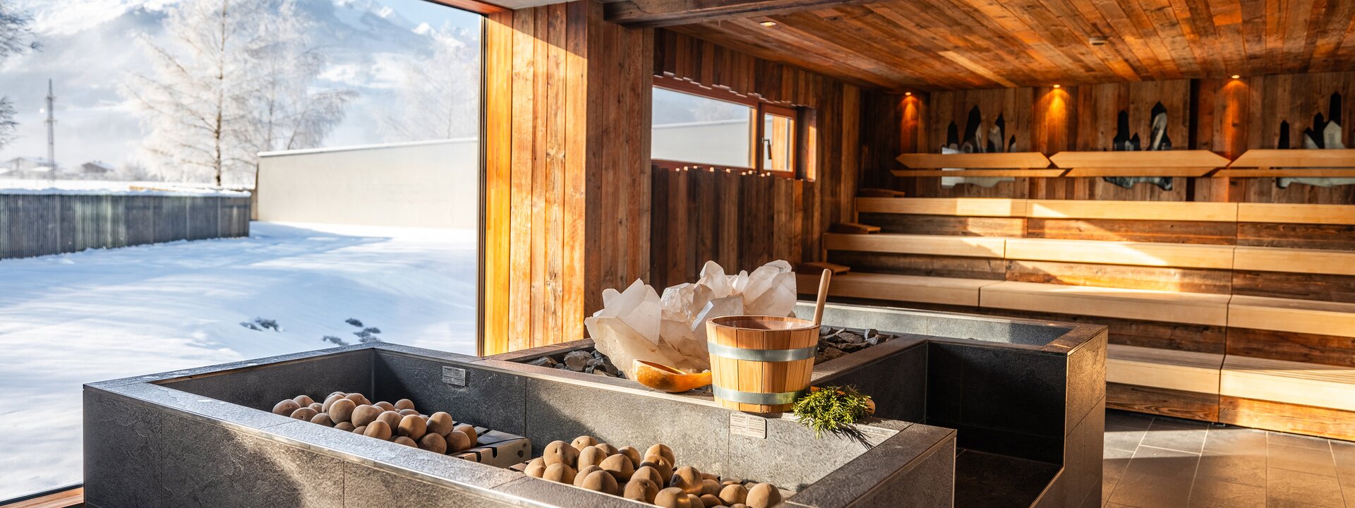 Innenansicht einer Sauna mit Eis, Holzelementen und Blick auf eine verschneite Landschaft