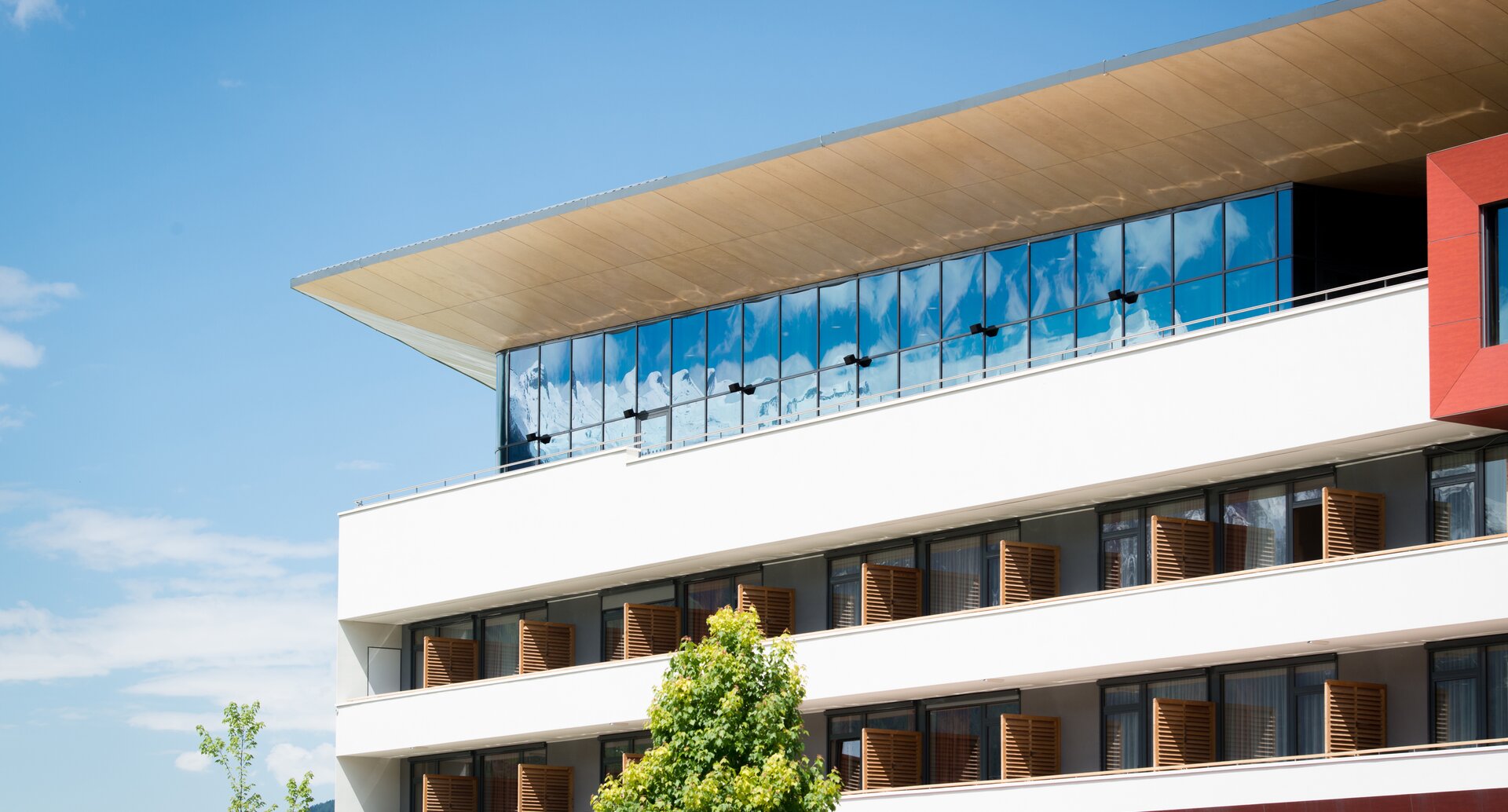Modern, white hotel building with glass facade under a blue sky