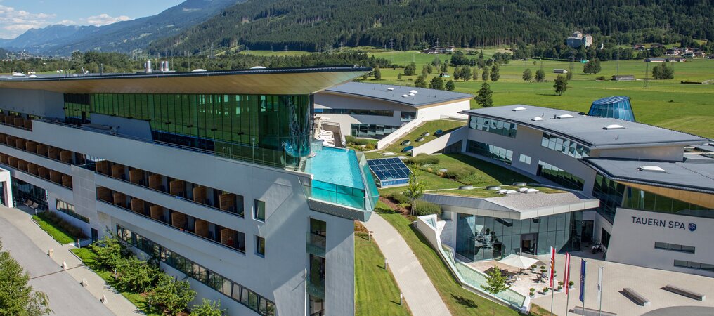 Hotelanlage mit Pool vor Berglandschaft im Sommer