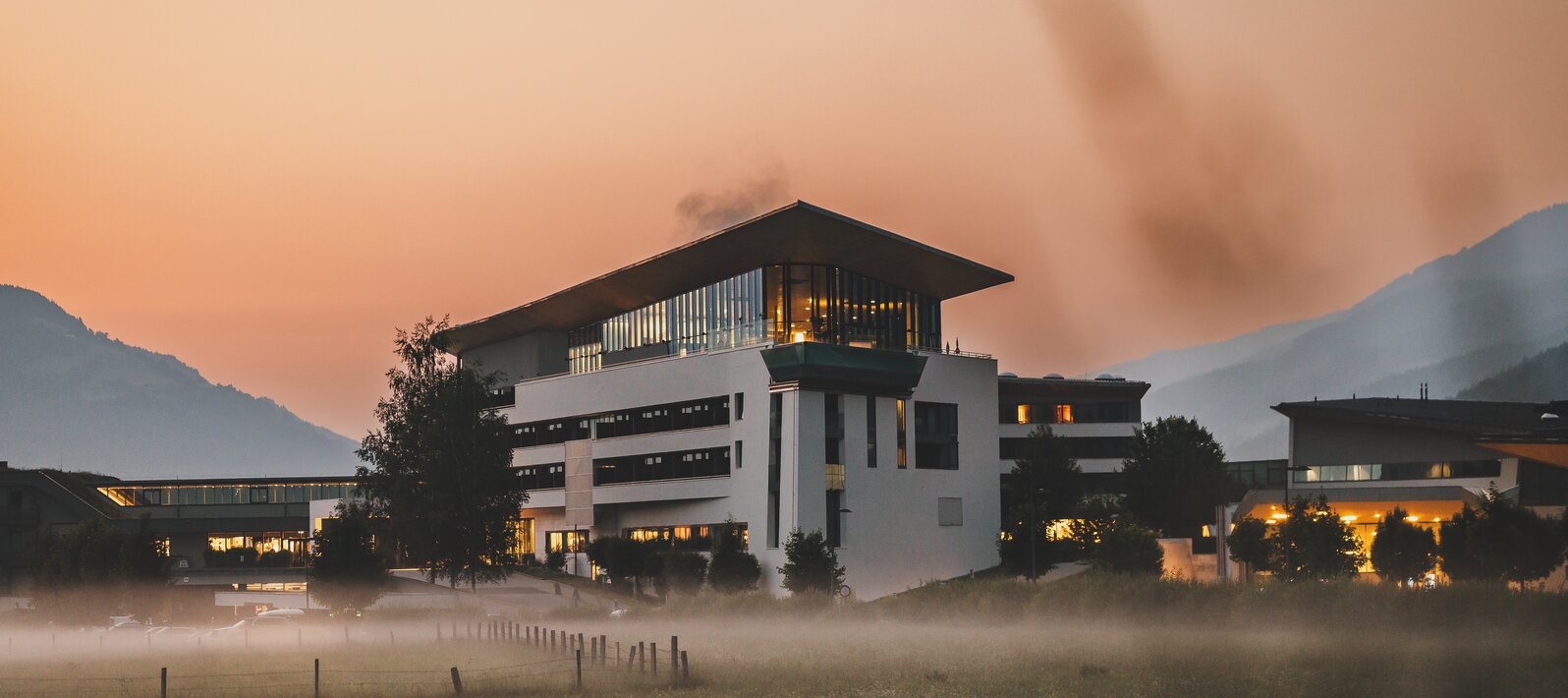 Beleuchteter Tauern SPA im Abendnebel vor Bergkulisse