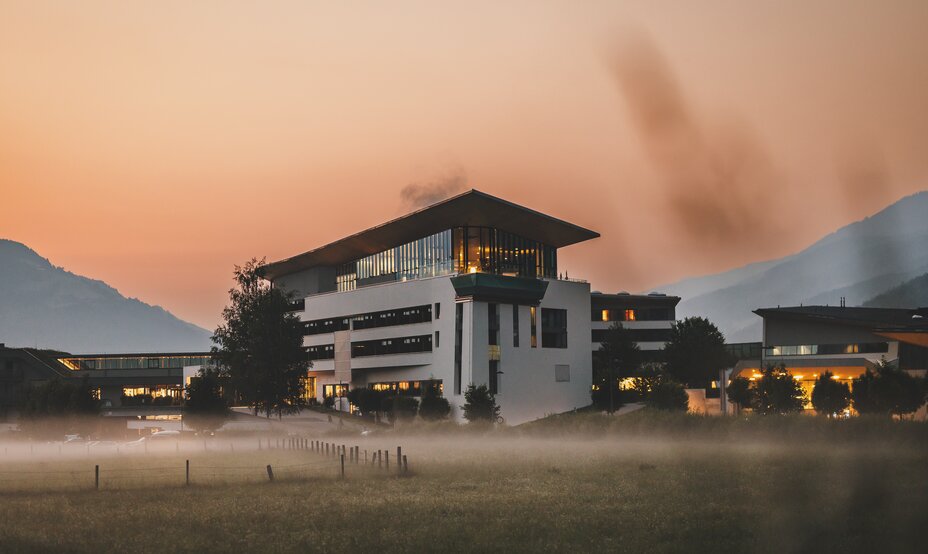 Beleuchteter Tauern SPA im Abendnebel vor Bergkulisse