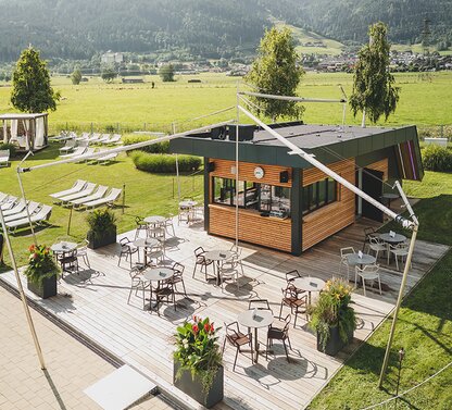 Wood-paneled café building with mountain views and sunbathing lawn