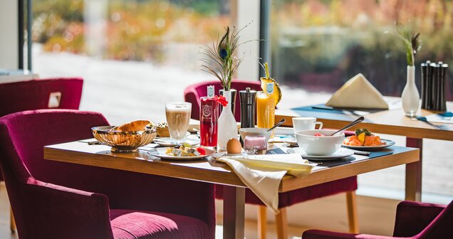 Set breakfast table with food, drinks and decoration in front of a window | © SPORTALPEN