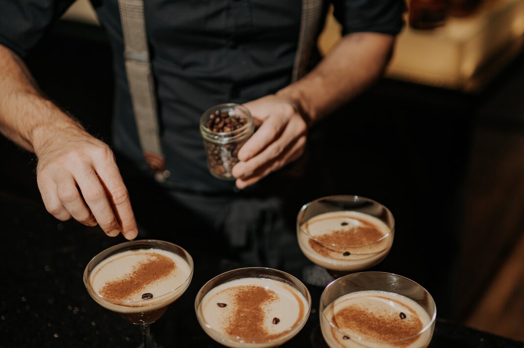 Barkeeper garniert Espresso Martinis mit Kaffeebohnen