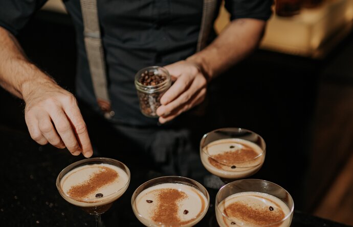 Barkeeper garniert Espresso Martinis mit Kaffeebohnen
