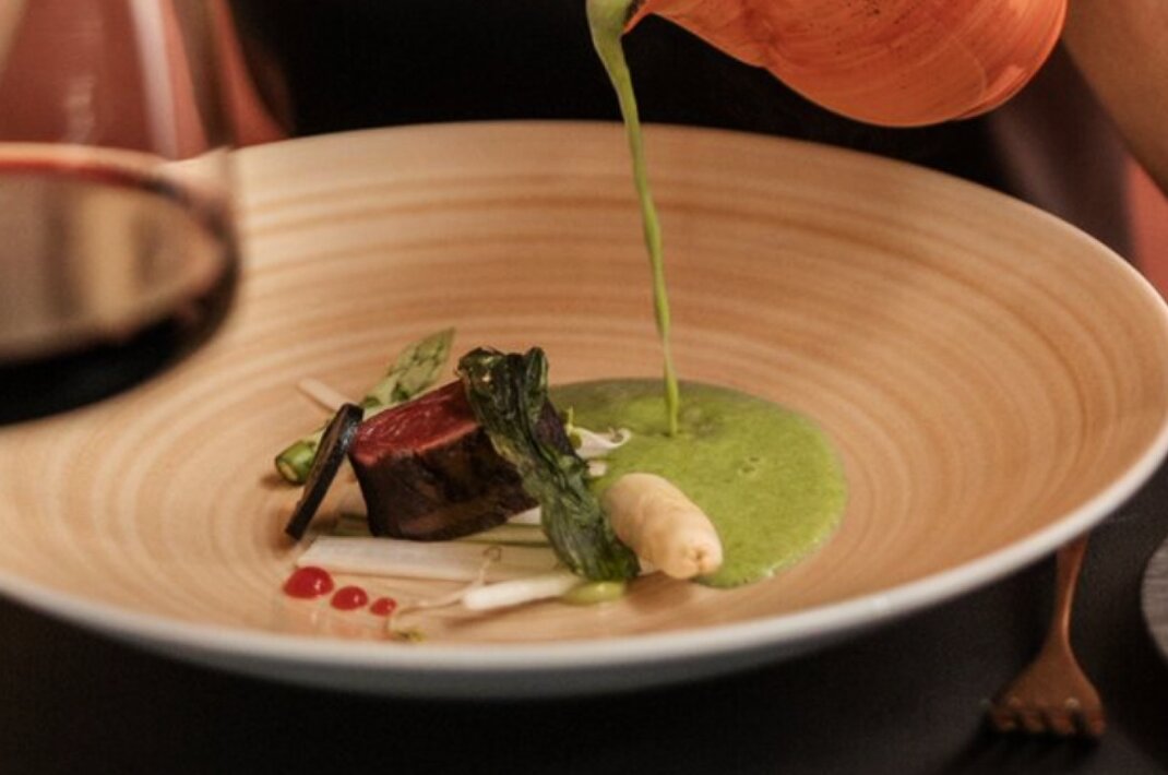 Grüne Soße über Fleischgericht mit Wein