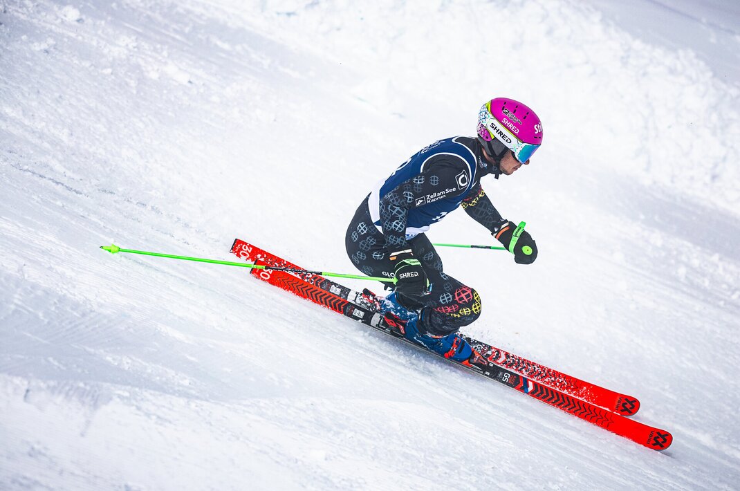 Skirennläufer in Rennhaltung auf verschneiter Piste
