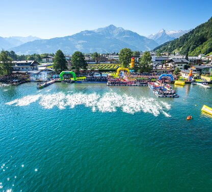 Ironman-Triathlon: Schwimmstart im See vor Bergkulisse