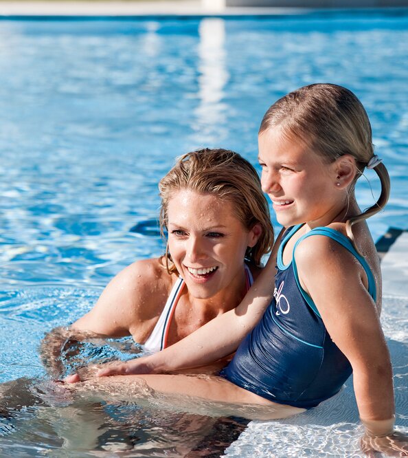 Mutter und Kind im Schwimmbad, lächelnd