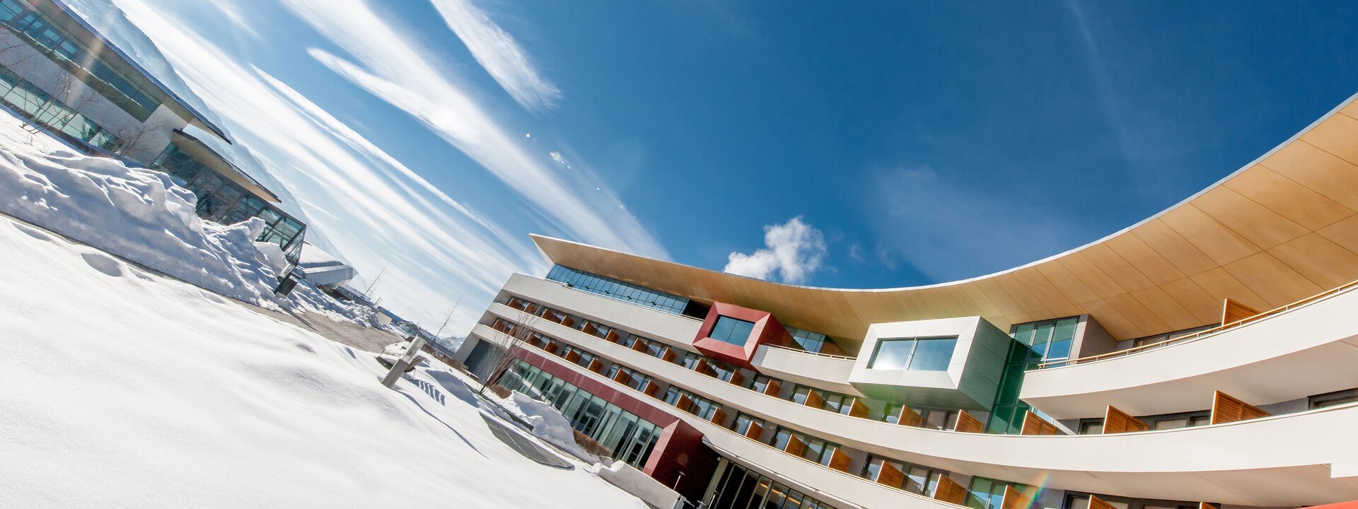 Exterior shot of a modern hotel in the snow under a blue sky