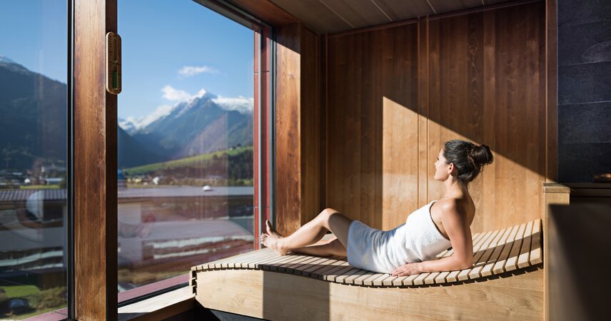 Frau in Sauna mit Bergblick