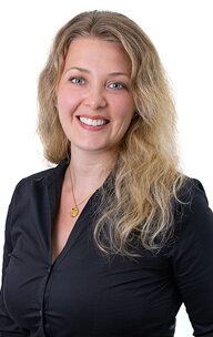 Lächelnde blonde Frau im schwarzen Hemd