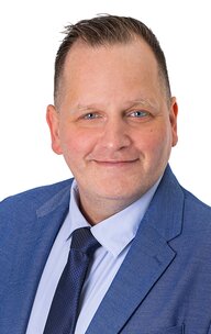 Lächelnder Mann im blauen Anzug vor weißem Hintergrund