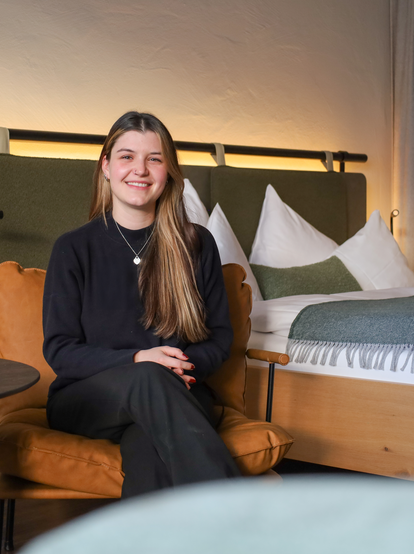 Lächelnde junge Frau in modernem Hotelzimmer