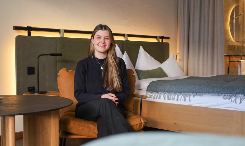 Lächelnde junge Frau in modernem Hotelzimmer