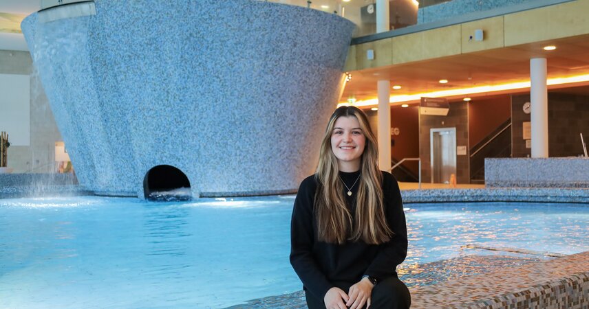 Lächelnde junge Frau am Schwimmbeckenrand