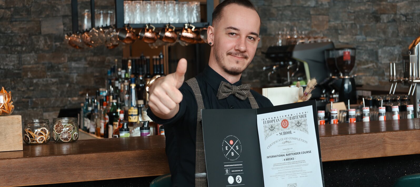 Glücklicher Barkeeper mit Zertifikat und Daumen