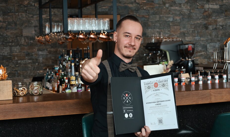 Glücklicher Barkeeper mit Zertifikat und Daumen