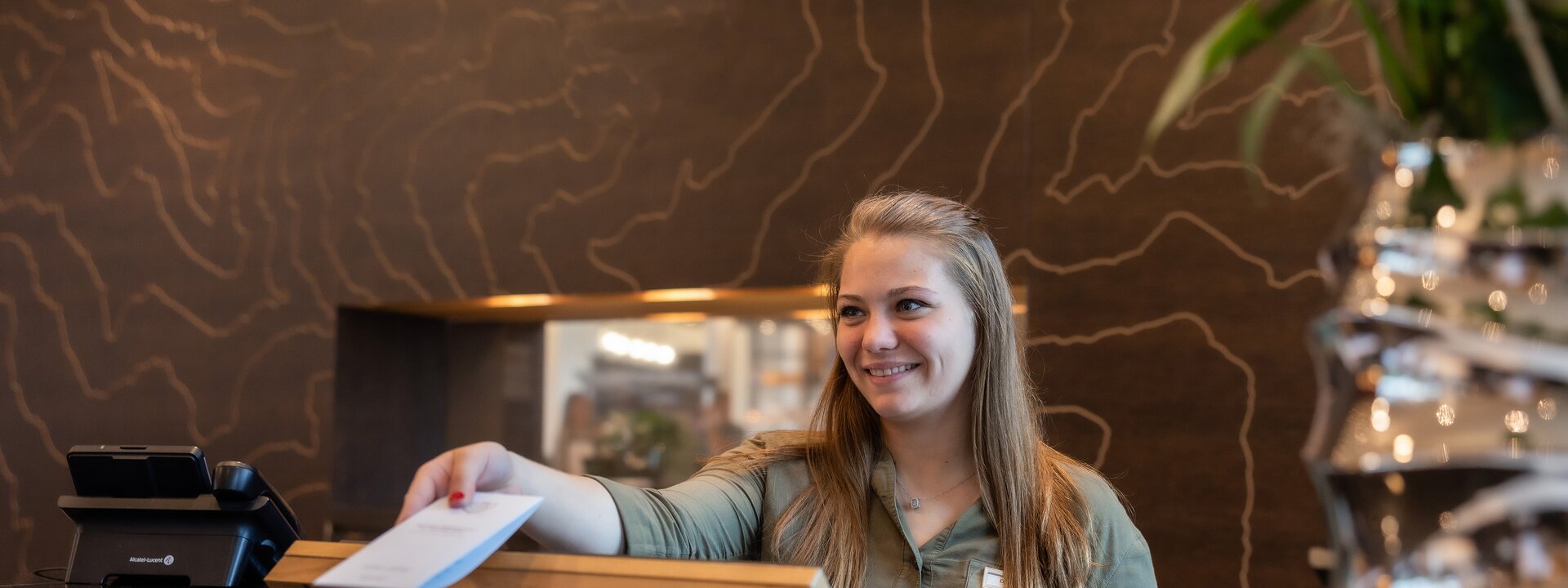 Woman at reception passes a document over the counter