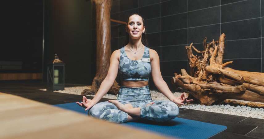 Lächelnde Frau in Yoga-Kleidung auf Matte