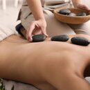 Hot stone massage on the back with dark stones and hands of a masseuse | © africa-studio.com (Olga Yastremska and Leonid Yastremskiy)