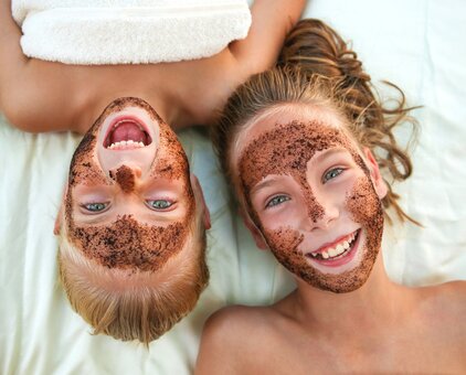 Two laughing children with face masks lying next to each other | © ©Victoria М - stock.adobe.com