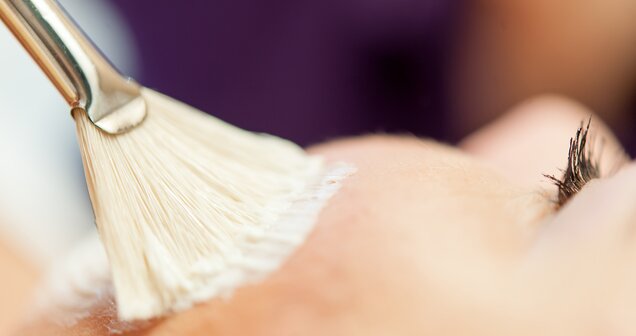 Hand holding brush with white paint against purple background | © Copyright 2012, Alexander Maria Lohmann