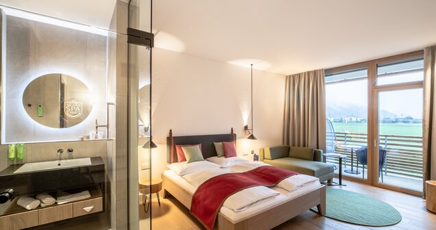 Double room with double bed, seating area and view through a window