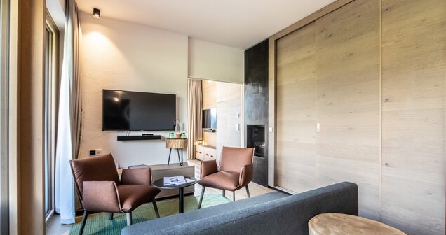 Helle Junior Suite mit Sofa, Sessel, TV und Holzelementen